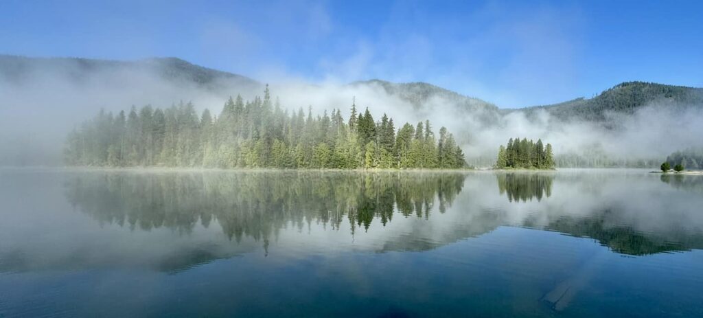 Private lake cabins Montana — Bull Lake dawn solitude with Cabinet Mountains reflection and no boat traffic