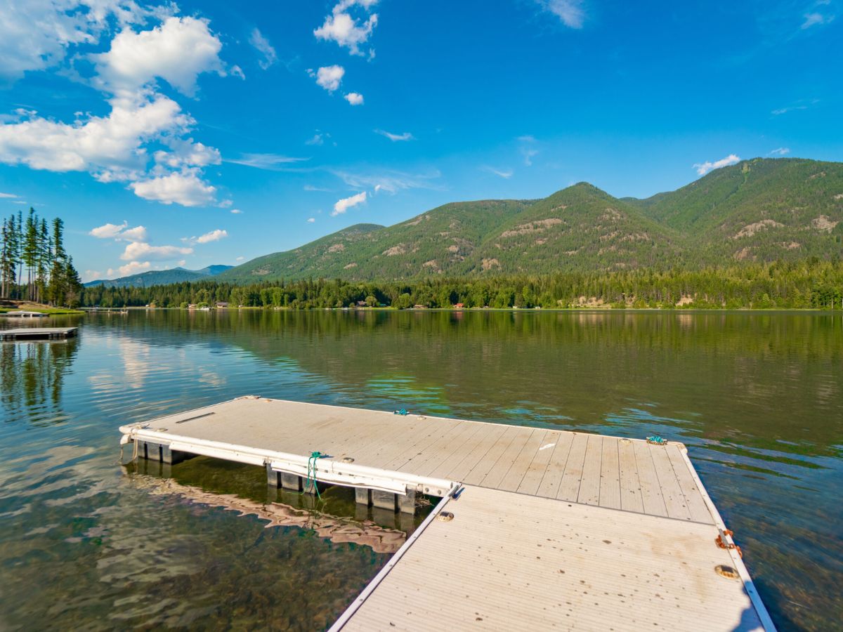 Private dock at Shangrilog reaching into a calm Bull Lake at sunrise, with the Cabinet Mountains beyond